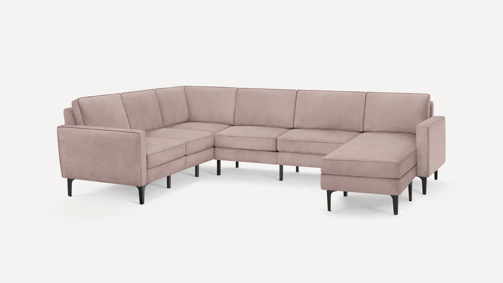 Light mauve U-shaped sectional sofa with clean lines, soft cushions, and black tapered legs on white background.