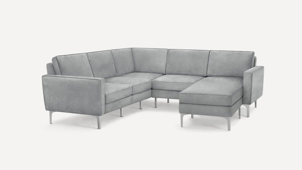 Modern L-shaped sectional sofa in light gray fabric with slim metal legs and clean, structured cushions.