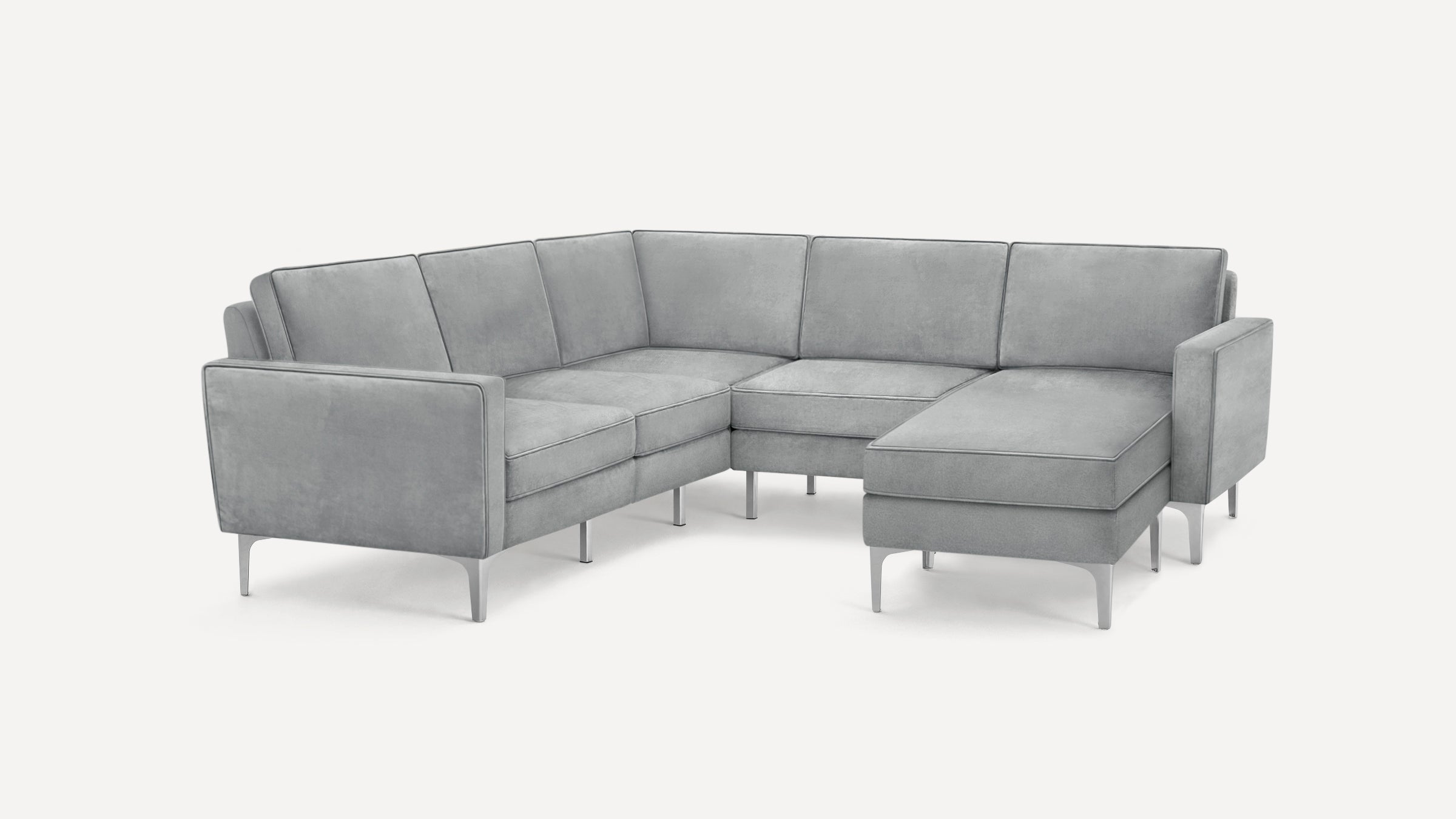 Modern L-shaped sectional sofa in light gray fabric with slim metal legs and clean, structured cushions.