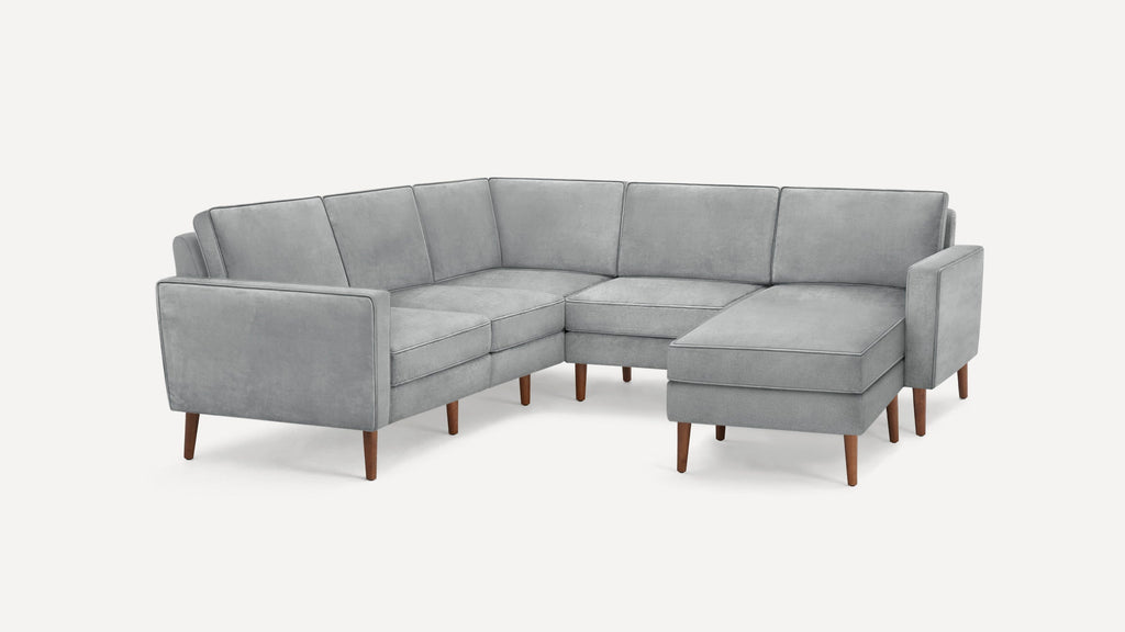 Modern light gray L-shaped sectional sofa with wooden legs and clean, square cushions on a white background.