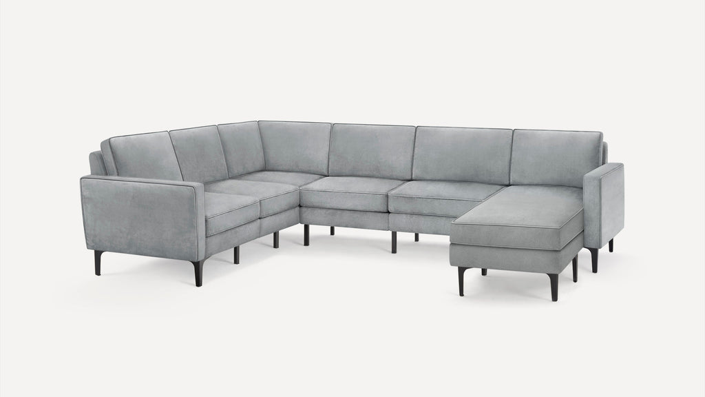 Modern light gray sectional sofa with a chaise lounge, slim armrests, and black tapered legs on a white background.
