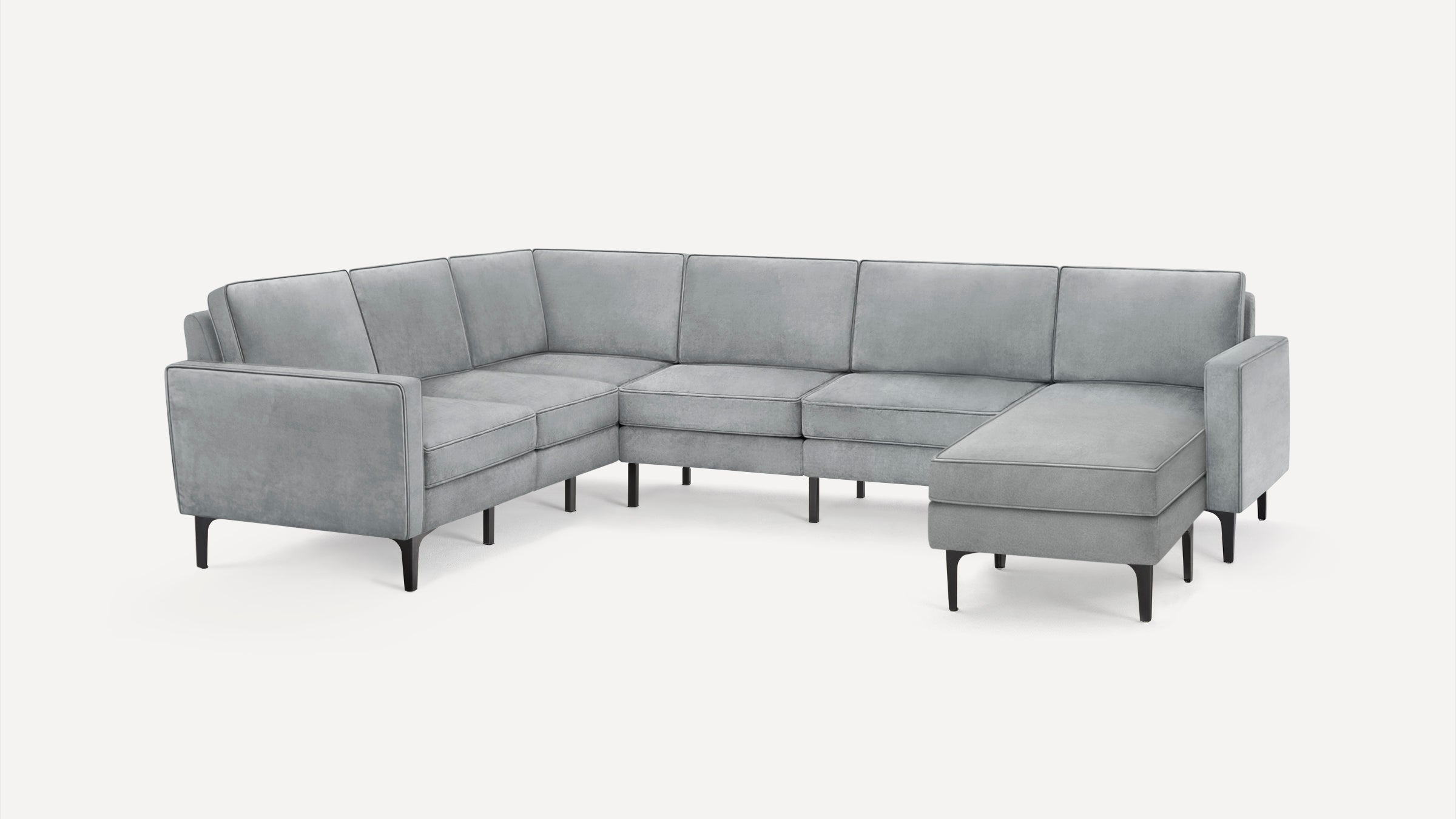 Modern light gray sectional sofa with a chaise lounge, slim armrests, and black tapered legs on a white background.