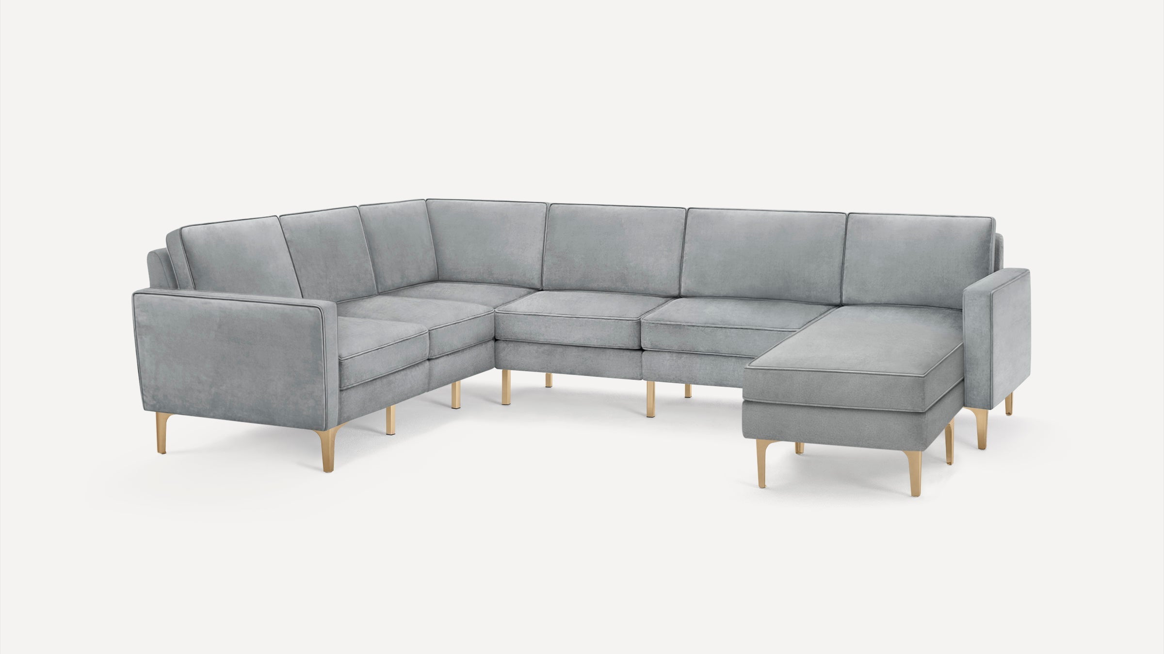 Modern L-shaped sectional sofa upholstered in light gray fabric with wooden legs and clean, contemporary design.