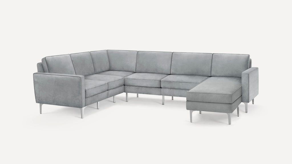 Modern L-shaped sectional sofa in light gray fabric with metal legs, featuring clean lines and a chaise lounge on the right side.