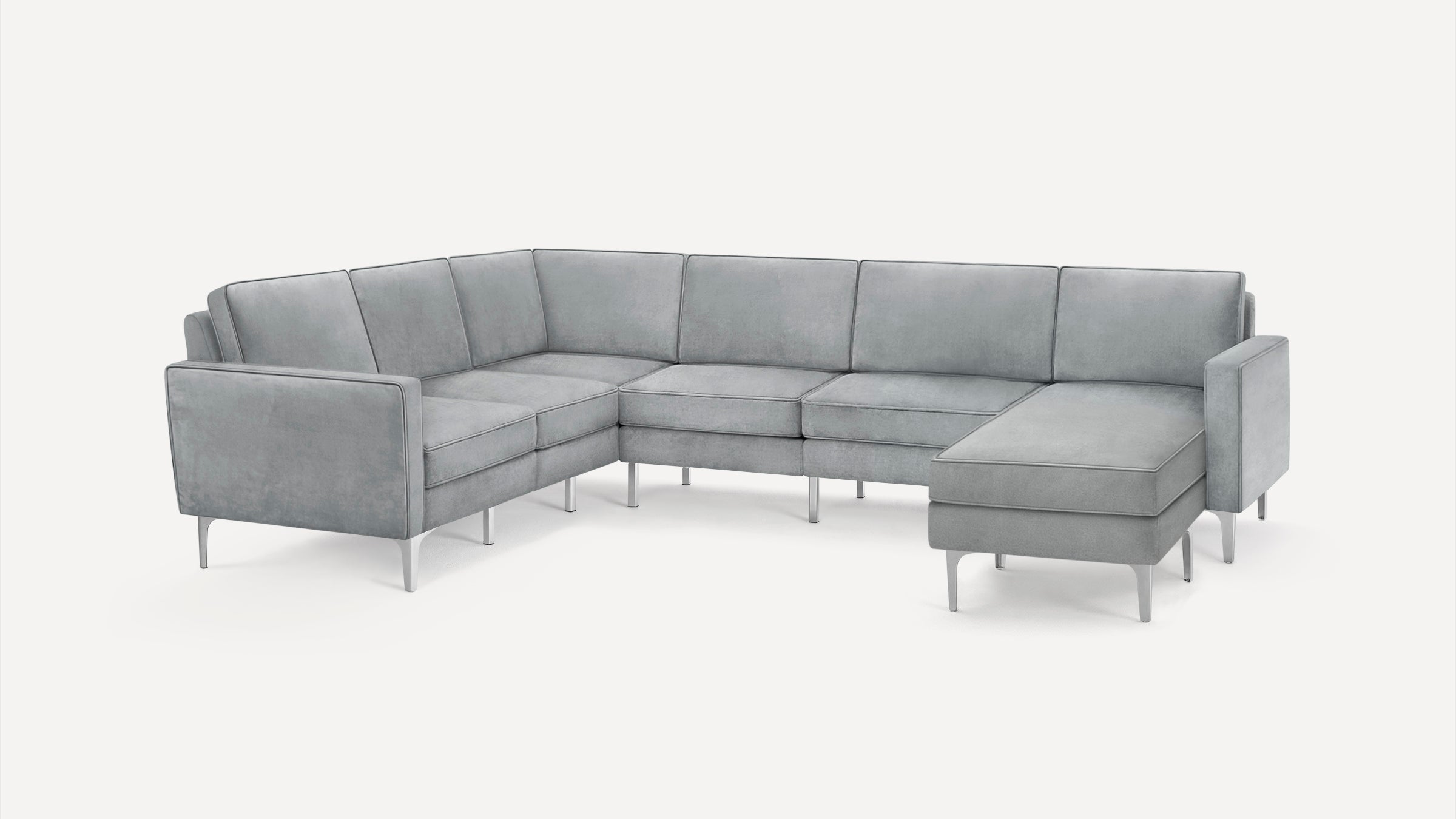 Modern L-shaped sectional sofa in light gray fabric with metal legs, featuring clean lines and a chaise lounge on the right side.