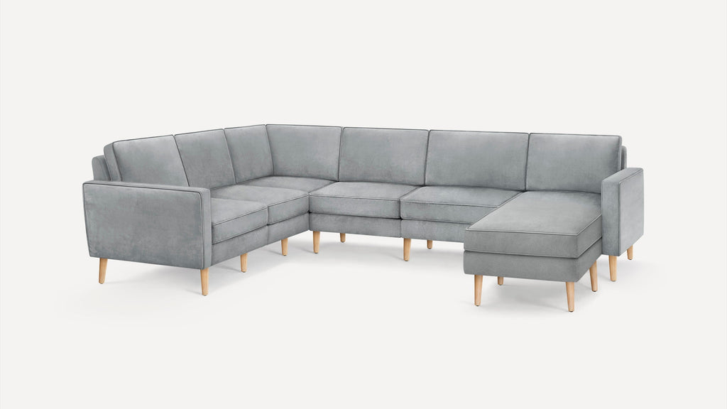 L-shaped modern sectional sofa in light grey fabric with clean lines and light wooden legs on a plain white background.