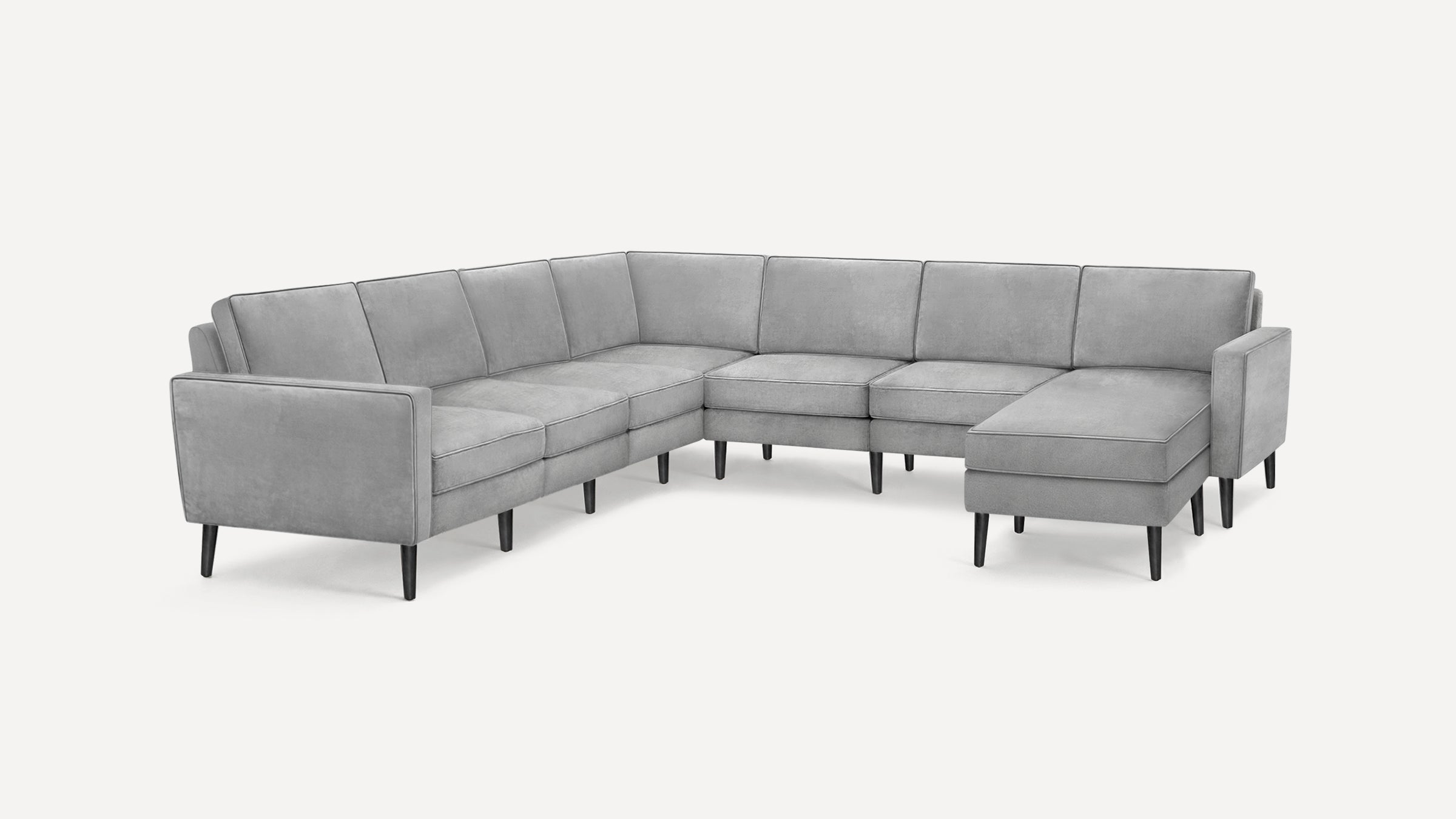 Modern L-shaped sectional sofa in light gray fabric with clean lines and slim black legs, featuring a right-side chaise lounge.