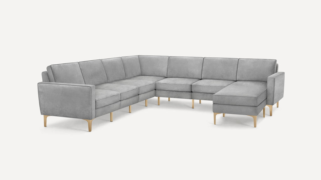 Large modern L-shaped sectional sofa in light gray fabric with sleek gold metal legs and clean lines.
