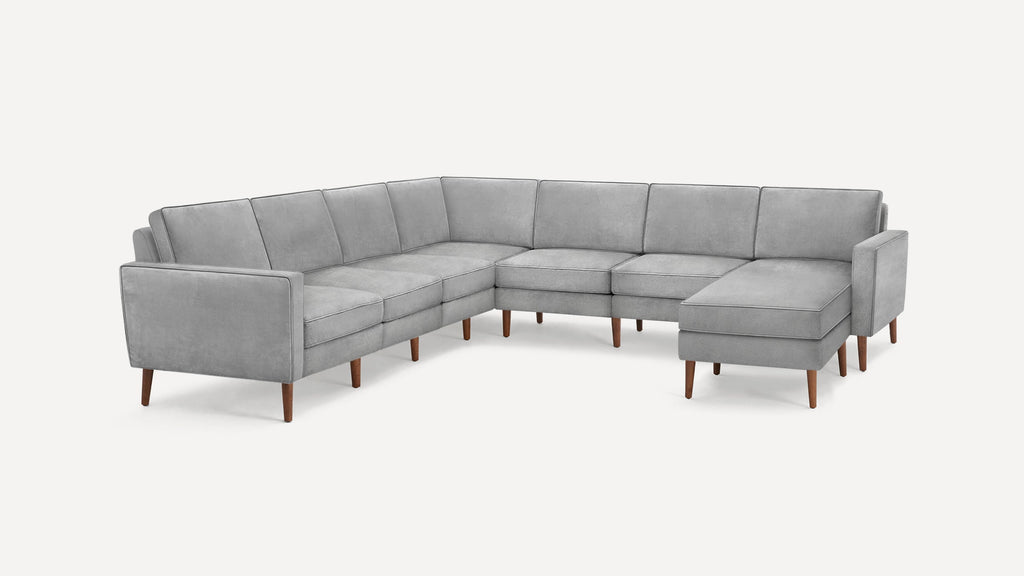 Modern L-shaped sectional sofa in light gray fabric with wooden tapered legs and clean, minimalist design.