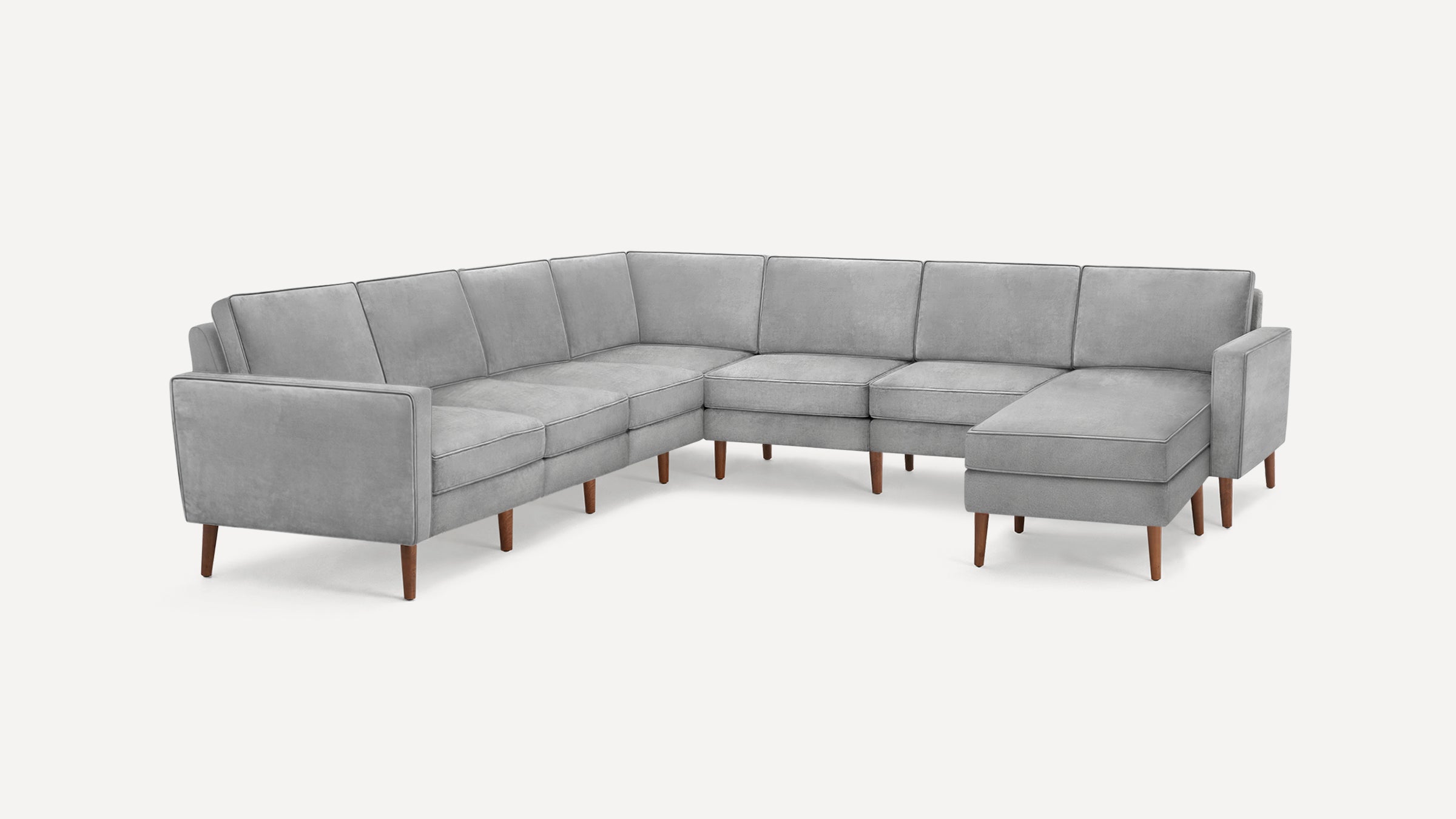 Modern L-shaped sectional sofa in light gray fabric with wooden tapered legs and clean, minimalist design.