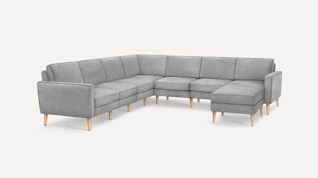Modern L-shaped sectional sofa with light gray fabric upholstery and wooden tapered legs on white background.