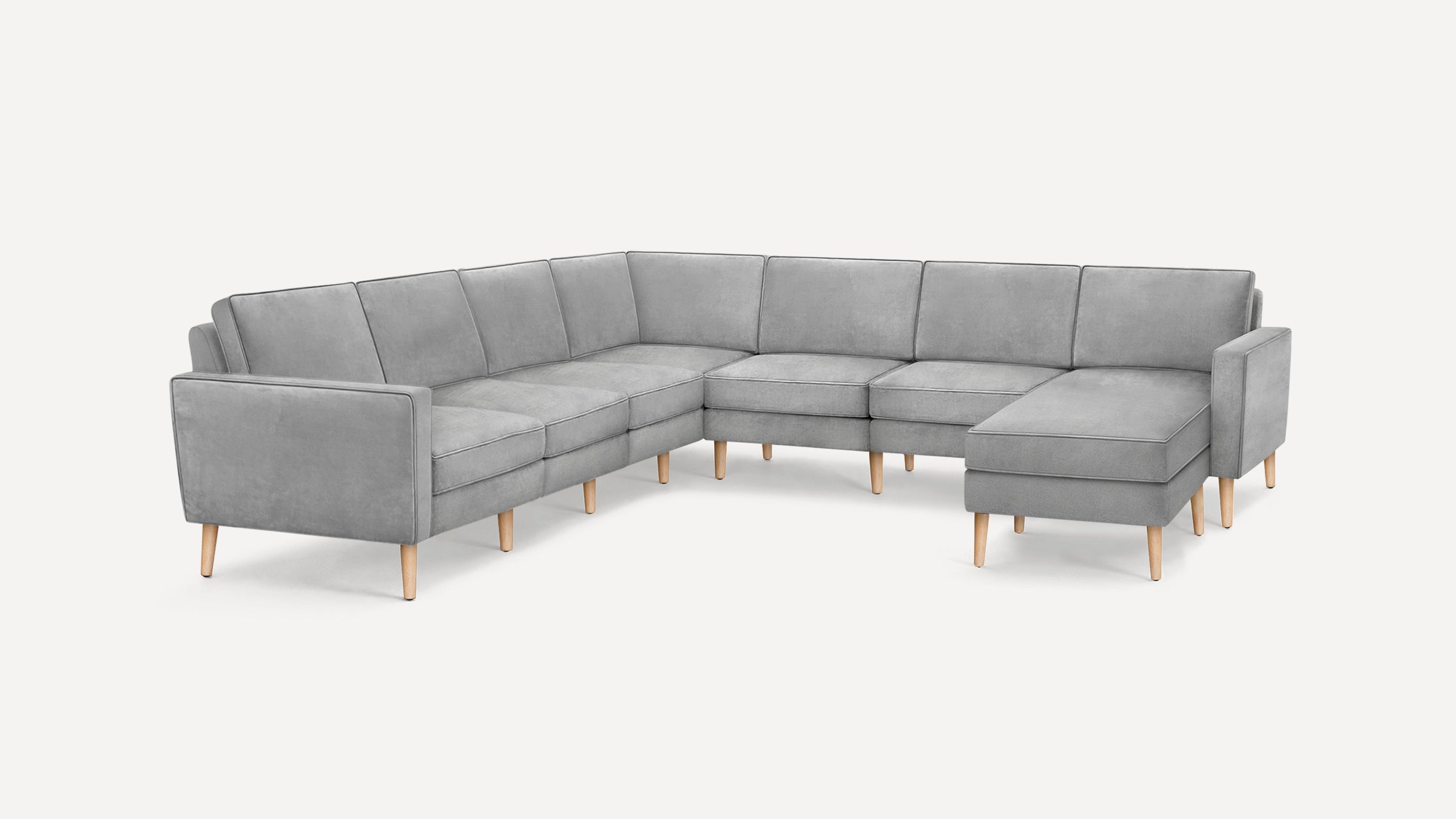 Modern L-shaped sectional sofa with light gray fabric upholstery and wooden tapered legs on white background.