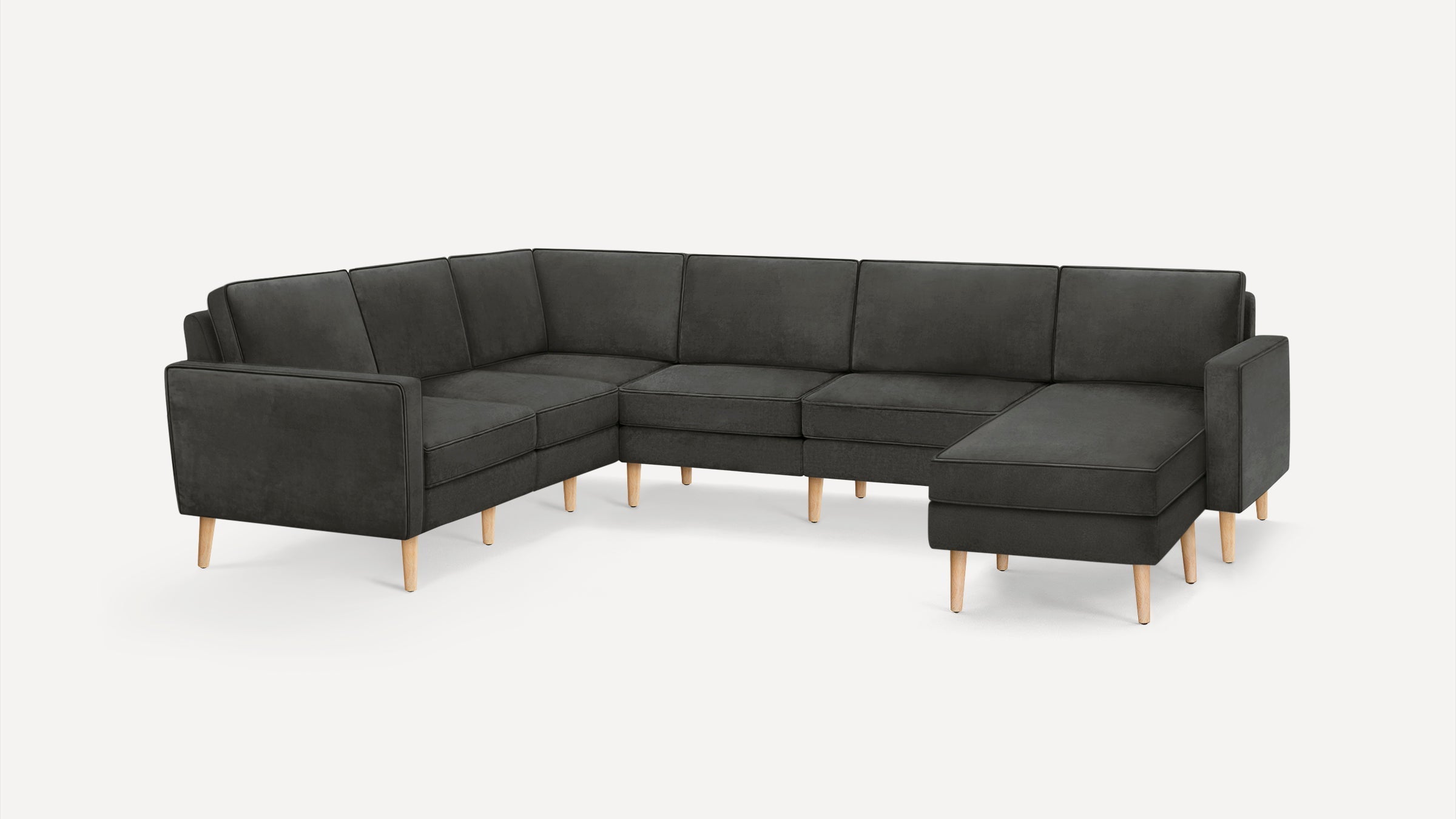 Dark gray L-shaped sectional sofa with clean lines, plush cushions, and light wooden legs on a white background.