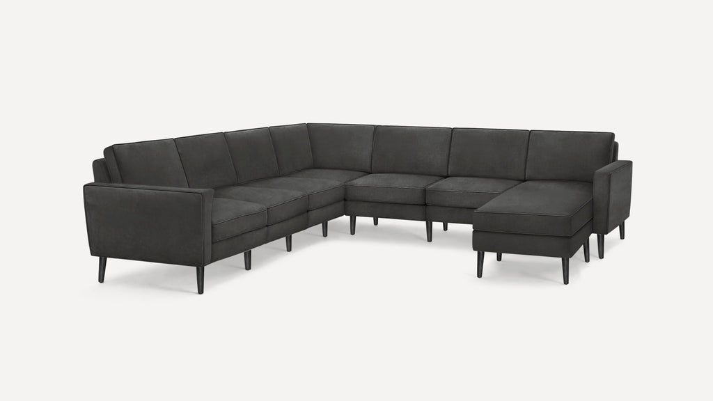 Dark gray modern sectional sofa with clean lines, tufted cushions, and tapered black wooden legs on white background.