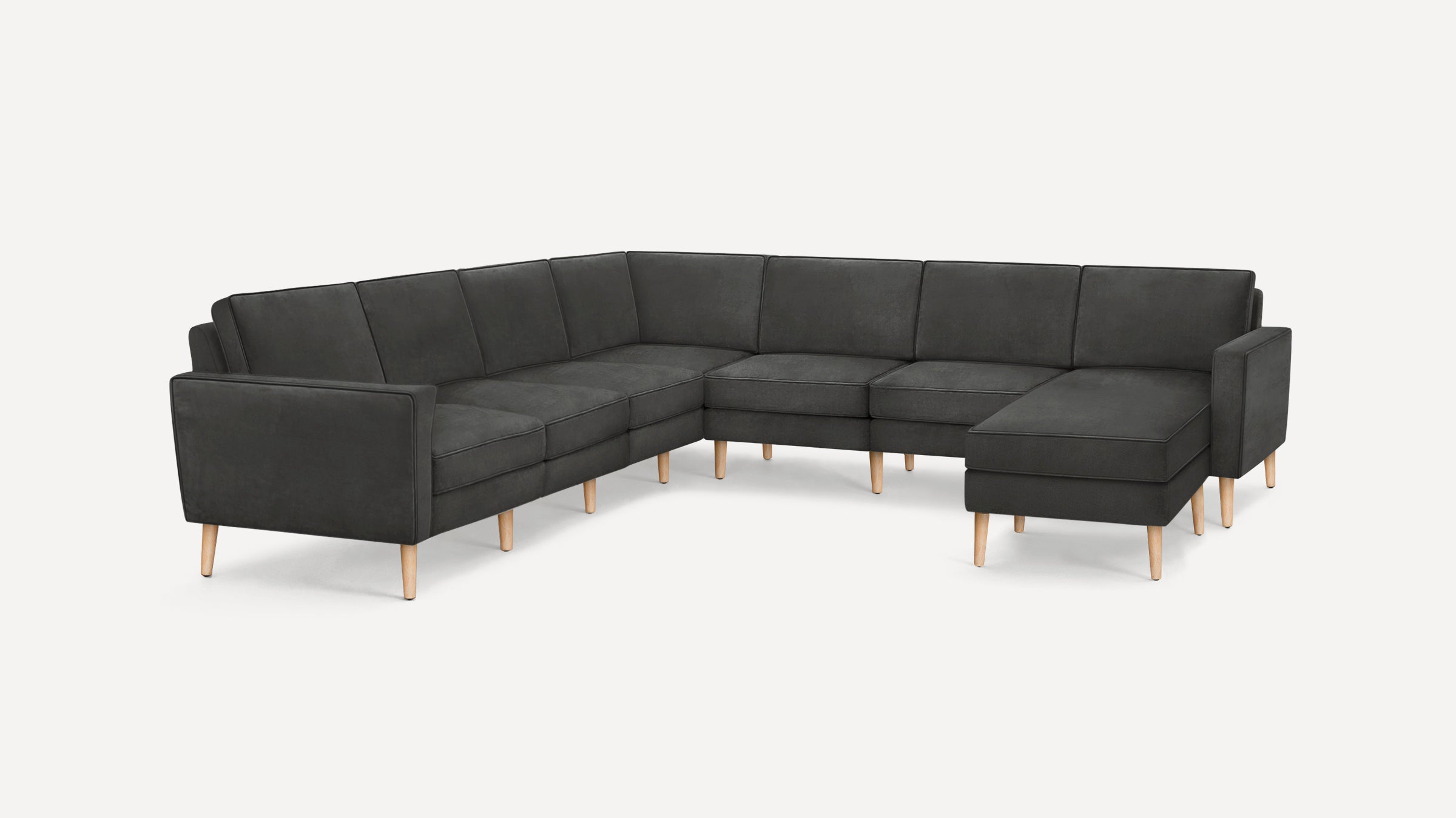 Large modern dark gray U-shaped sectional sofa with wooden legs on white background, featuring a chaise lounge on the right side.