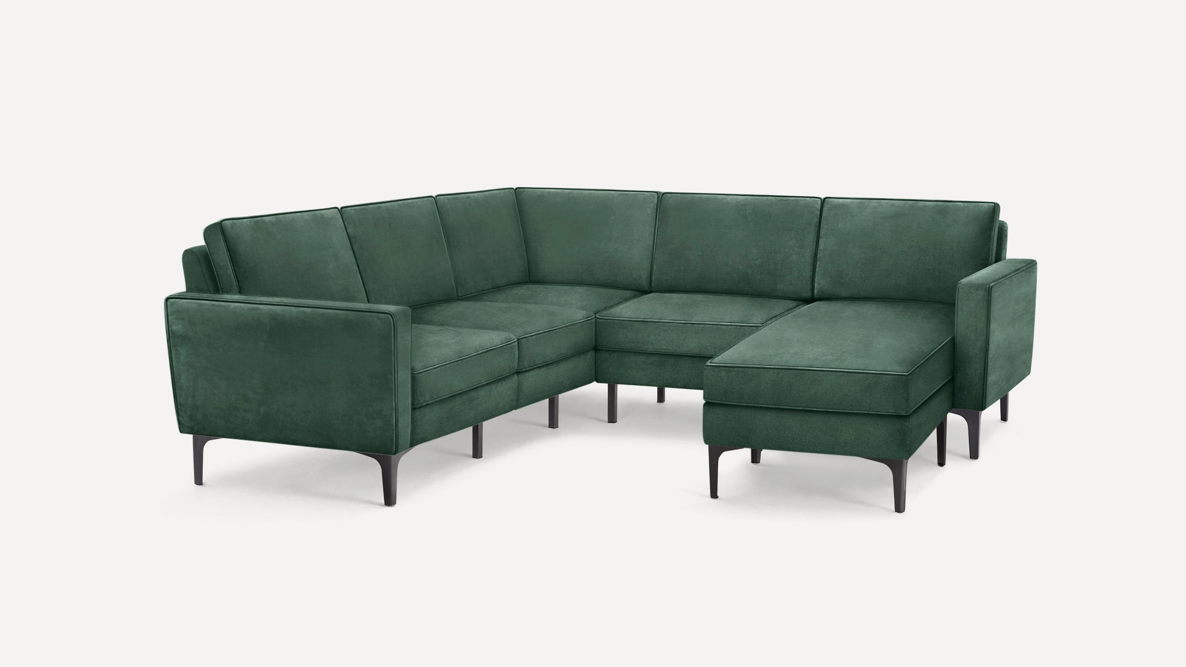 Modern sectional sofa in dark green velvet upholstery with metal legs and clean, minimalist design.