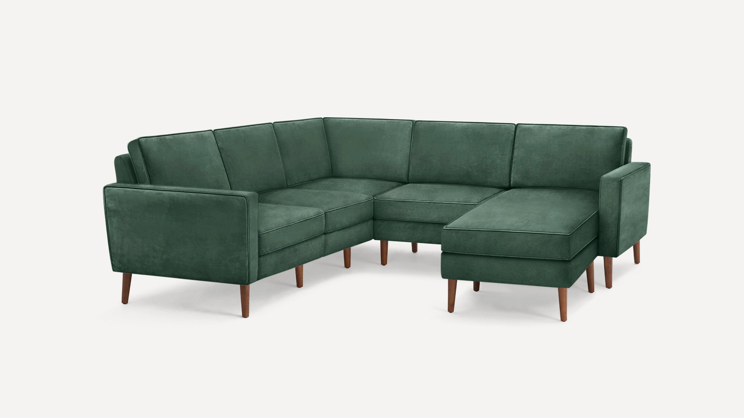 Dark green velvet L-shaped sectional sofa with wooden legs, featuring a modern, minimalist design and separate cushioned seats and backrests.