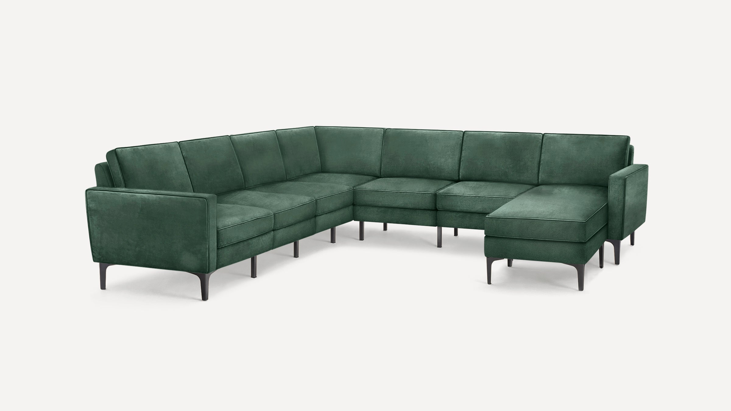 Modern L-shaped sectional sofa in dark green velvet upholstery with slim black metal legs, featuring clean lines and cushioned seats.