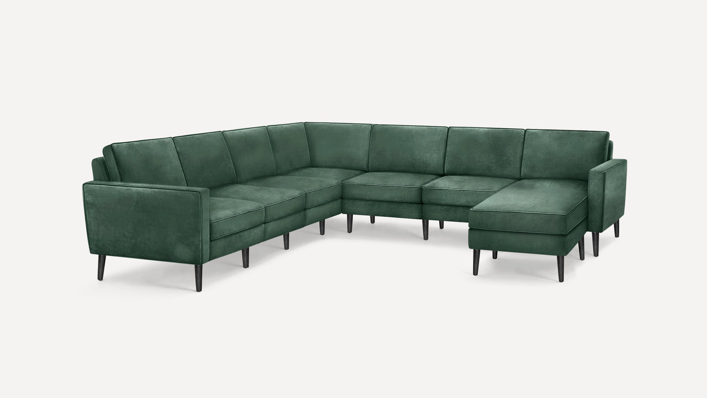 Modern L-shaped sectional sofa upholstered in dark green velvet fabric with clean lines and black tapered legs.