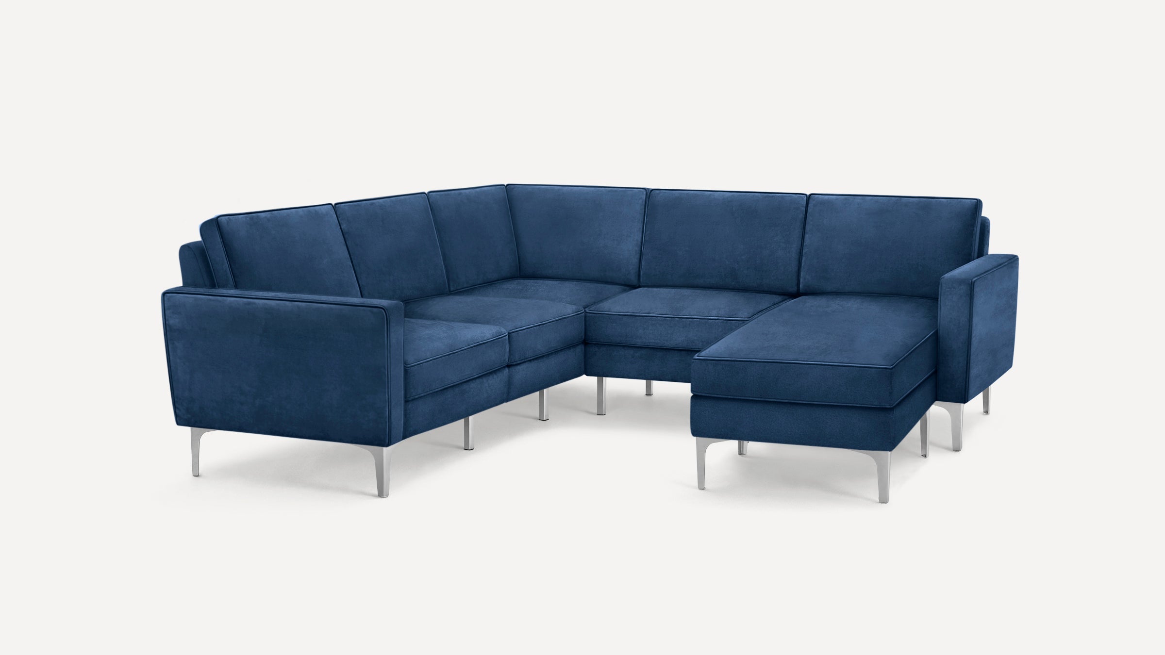 Modern navy blue velvet sectional sofa with clean lines, chrome legs, and plush cushions in an L-shaped configuration.