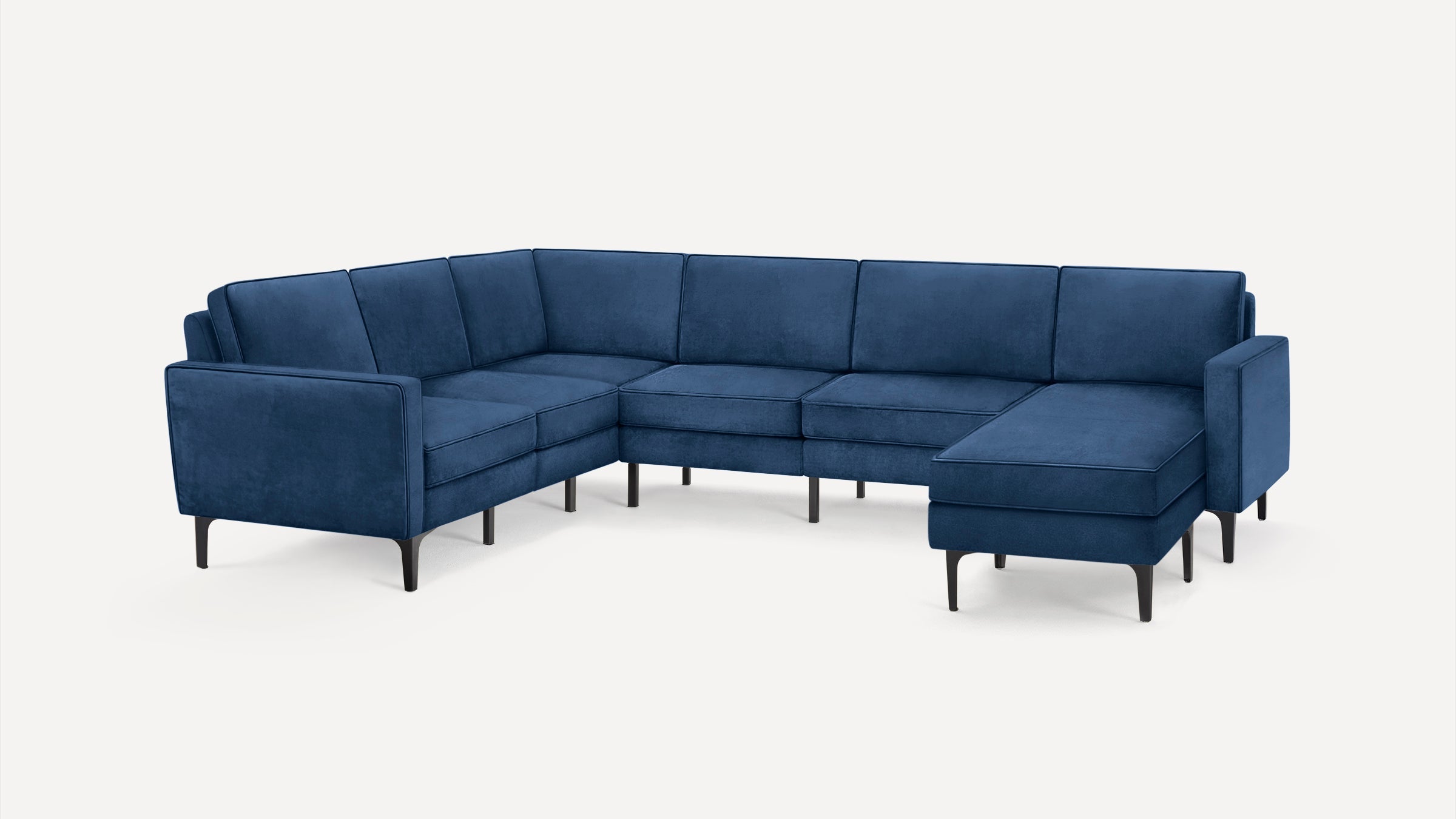 Modern L-shaped sectional sofa in deep blue with slim black legs and clean, plush cushioning for comfortable seating.