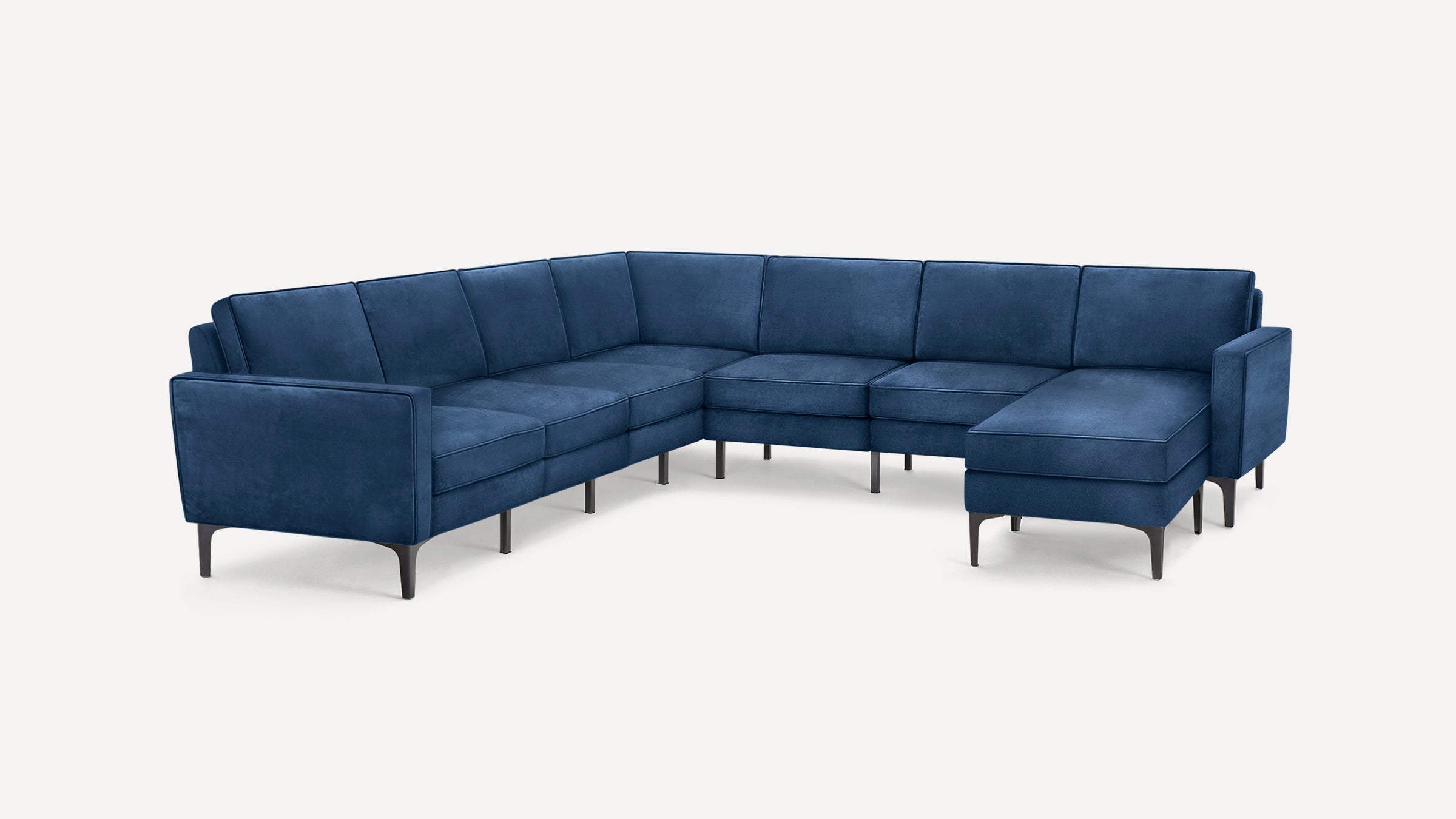 Modern L-shaped sectional sofa upholstered in deep blue fabric with slim black metal legs and clean, cushioned seats and backrests.