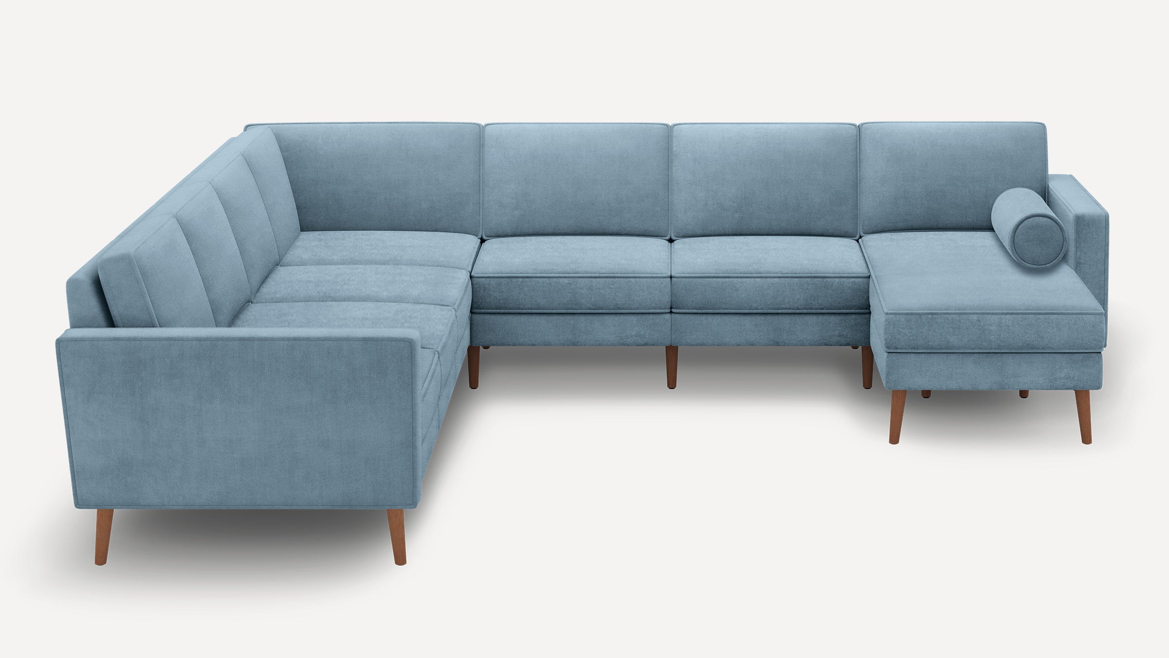 Light blue L-shaped sectional sofa with mid-century wooden legs and a cylindrical bolster pillow on right chaise.