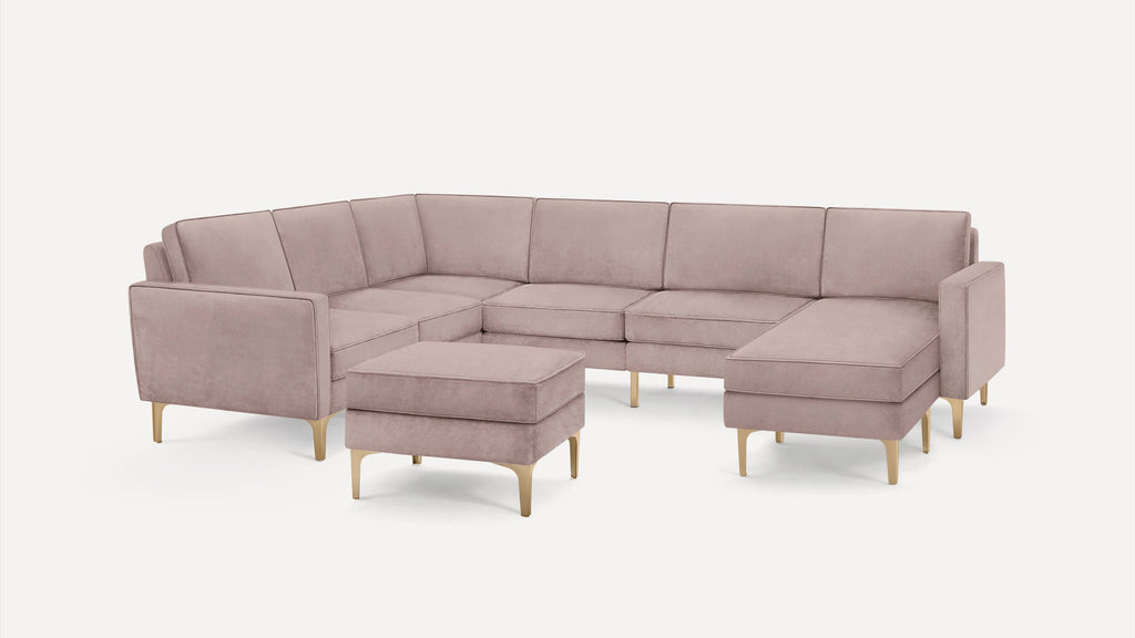 Light pink modern sectional sofa with matching ottoman, gold metal legs, and clean, minimalist design on white background.