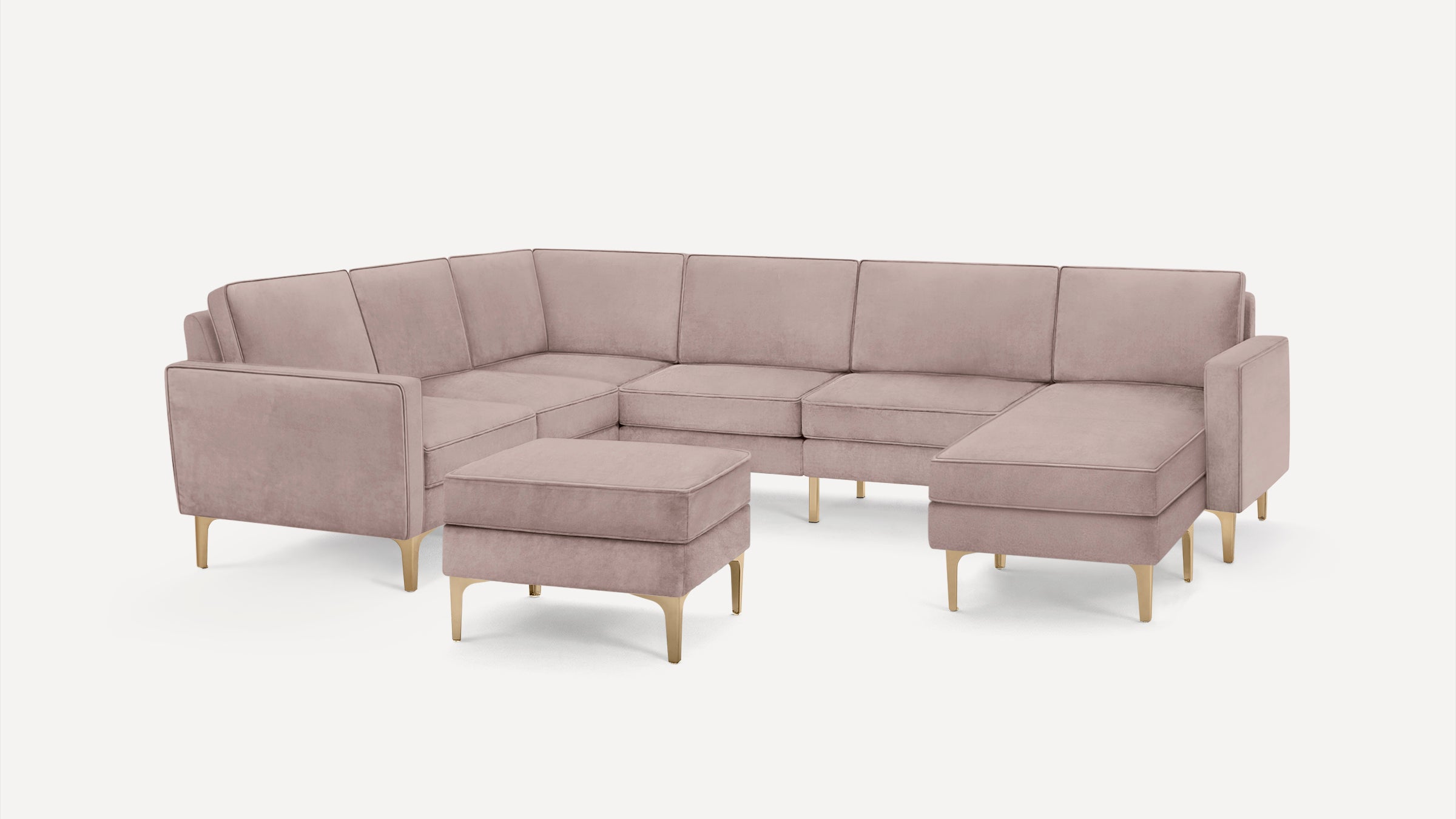 Light pink modern sectional sofa with matching ottoman, gold metal legs, and clean, minimalist design on white background.