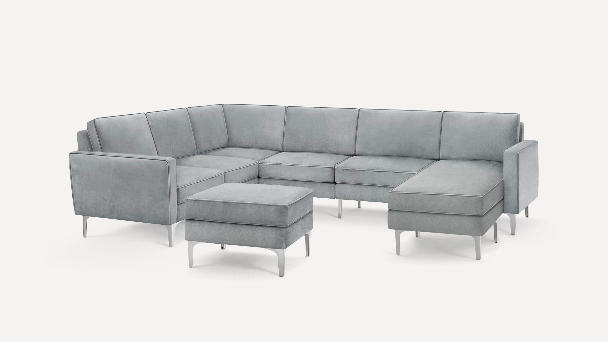 Modern light gray sectional sofa with sleek metal legs and matching ottoman on a white background.
