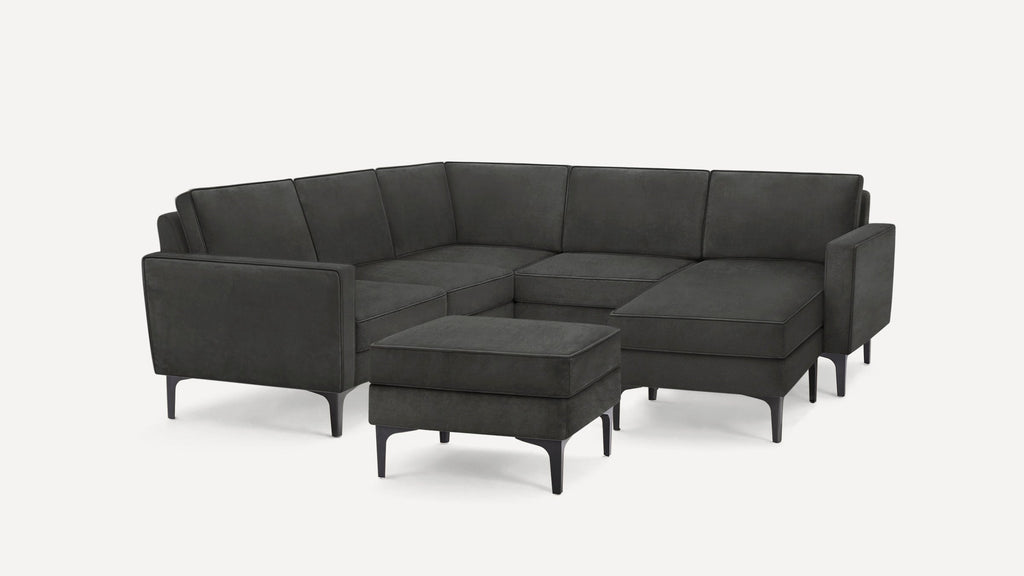 Dark gray modern L-shaped sectional sofa with clean lines and thin black legs, accompanied by a matching square ottoman.