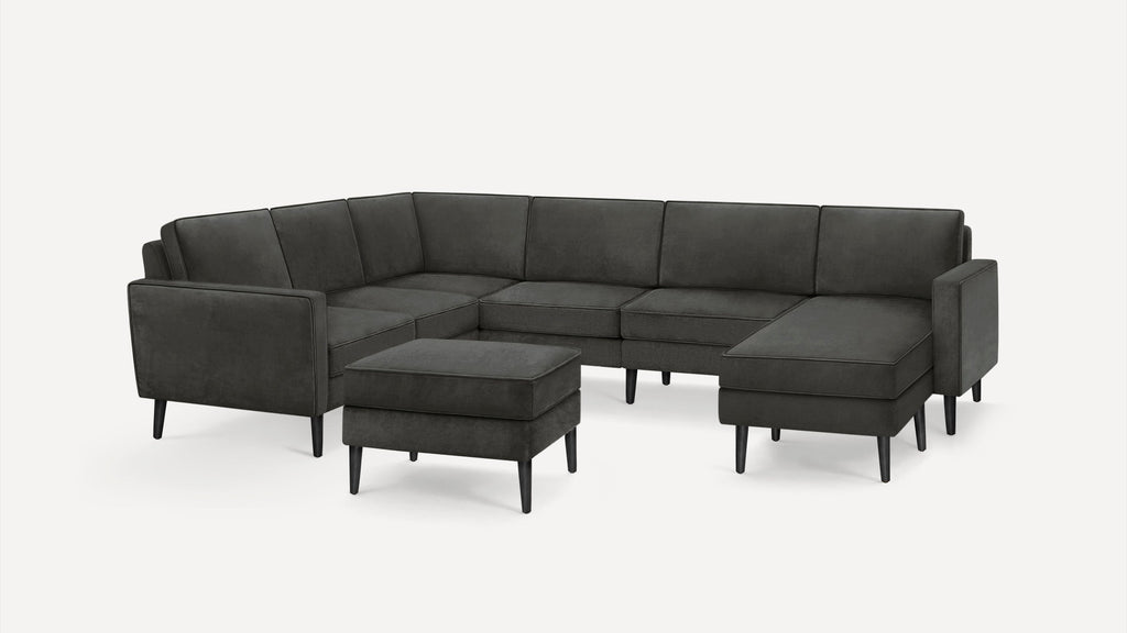 Dark gray modern sectional sofa with separate ottoman, featuring sleek wooden legs and clean, minimalist design.