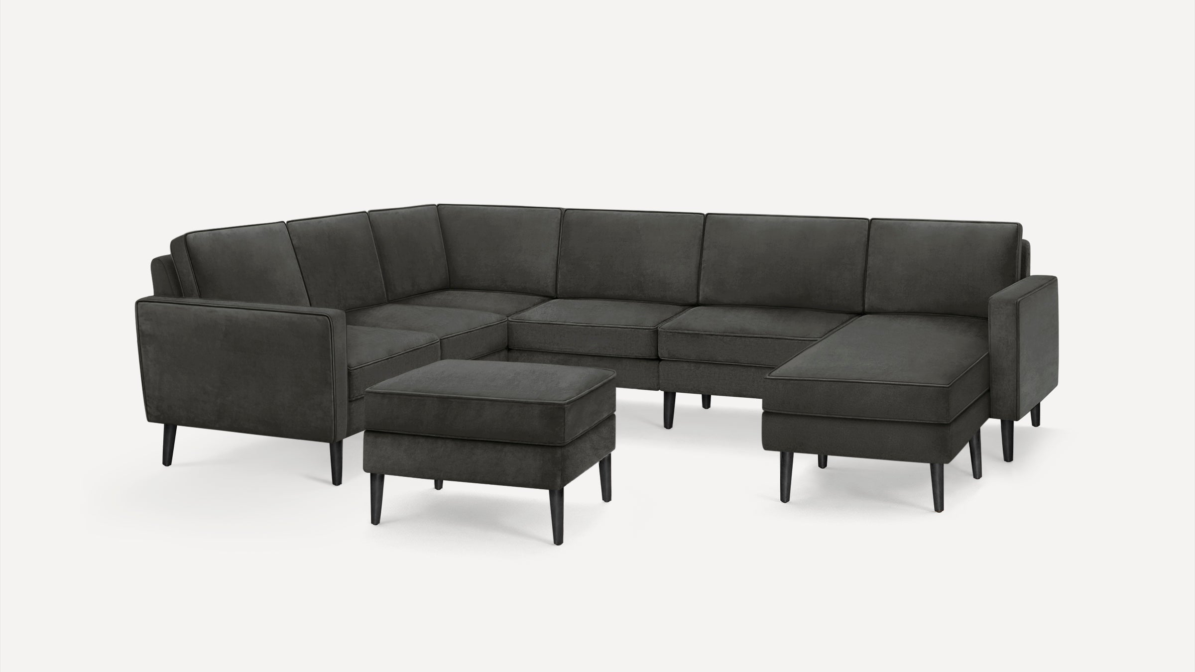 Dark gray modern sectional sofa with separate ottoman, featuring sleek wooden legs and clean, minimalist design.