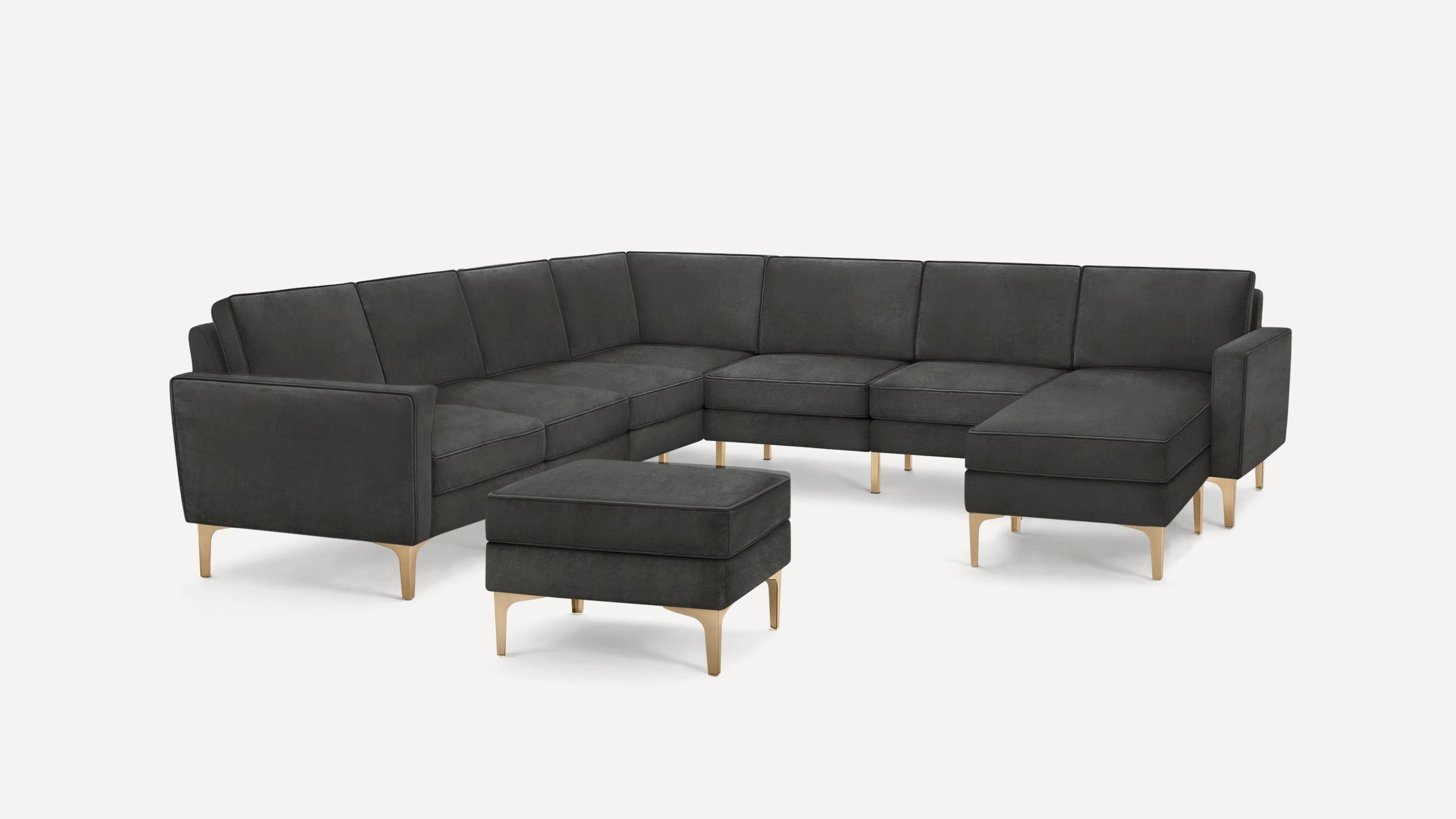 Modern dark gray L-shaped sectional sofa with tufted cushions and light wooden legs, including matching ottoman.