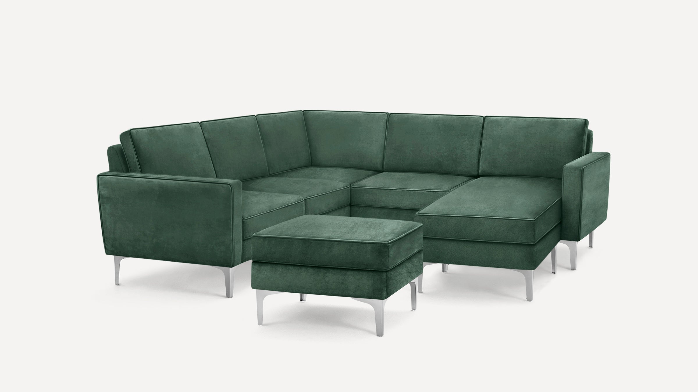 Modern green velvet L-shaped sectional sofa with metal legs and matching ottoman, shown on white background.