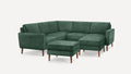 Dark green velvet sectional sofa with wooden legs and a matching ottoman, displayed on a white background.