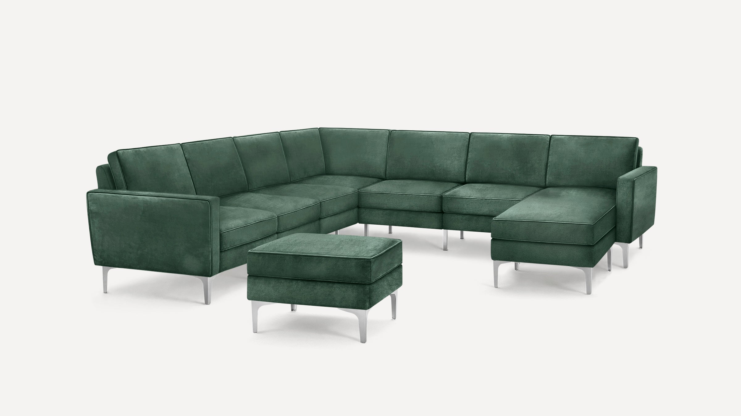 Modern green sectional velvet sofa with a matching ottoman, featuring sleek metal legs and clean lines on a white background.