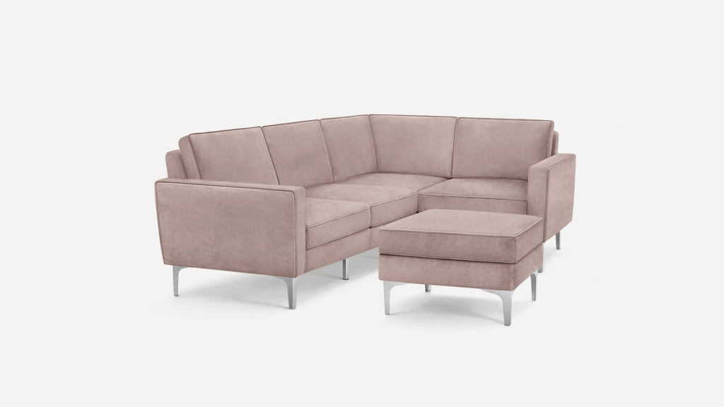 Modern L-shaped sectional sofa in soft mauve velvet with slim metal legs and matching ottoman.