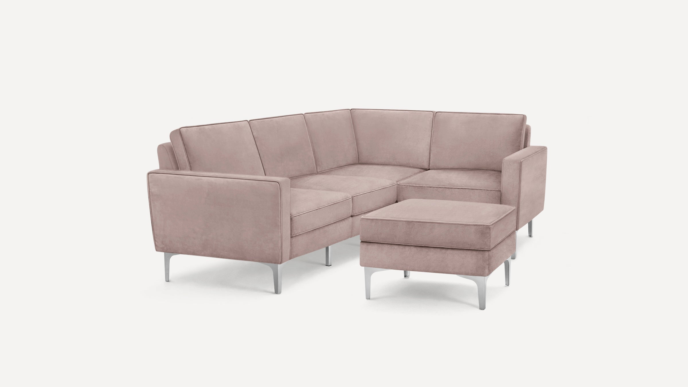 Modern L-shaped sectional sofa in soft mauve velvet with slim metal legs and matching ottoman.