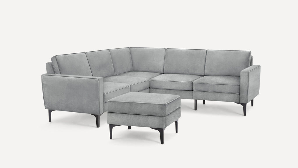 Modern light gray sectional sofa with clean lines, cushioned seats, backrests, and matching ottoman on black legs.