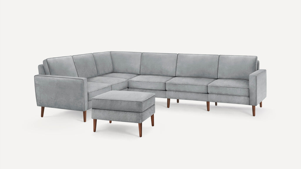 Light gray sectional sofa with clean lines and wooden tapered legs, accompanied by a matching ottoman.