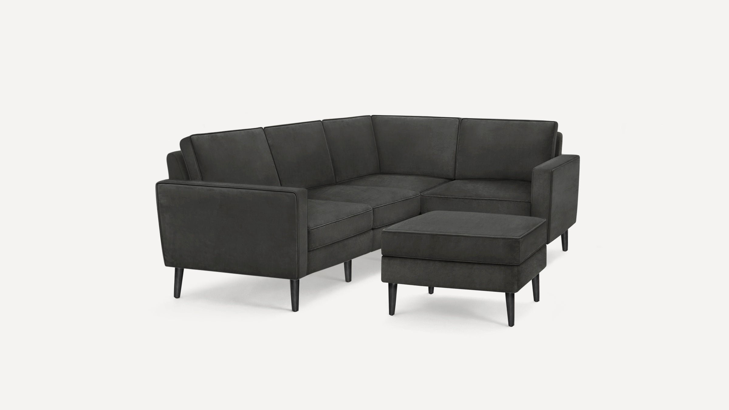 Dark gray modern sectional sofa with clean lines and matching ottoman, supported by tapered black legs.