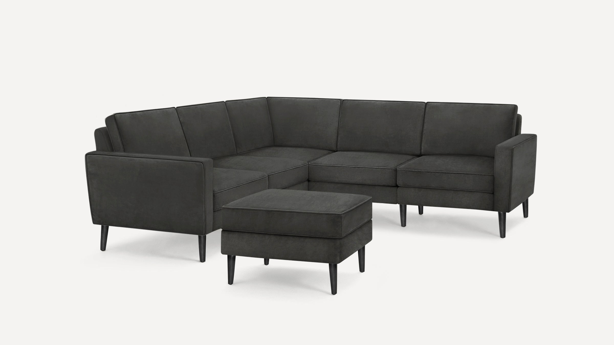 Modern dark gray L-shaped sectional sofa with matching ottoman, featuring clean lines and tapered black legs.