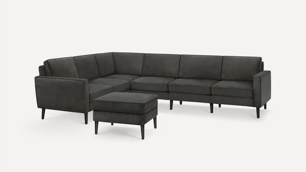 Dark gray modern sectional sofa with clean lines and matching ottoman, featuring tapered black legs and plush cushions.
