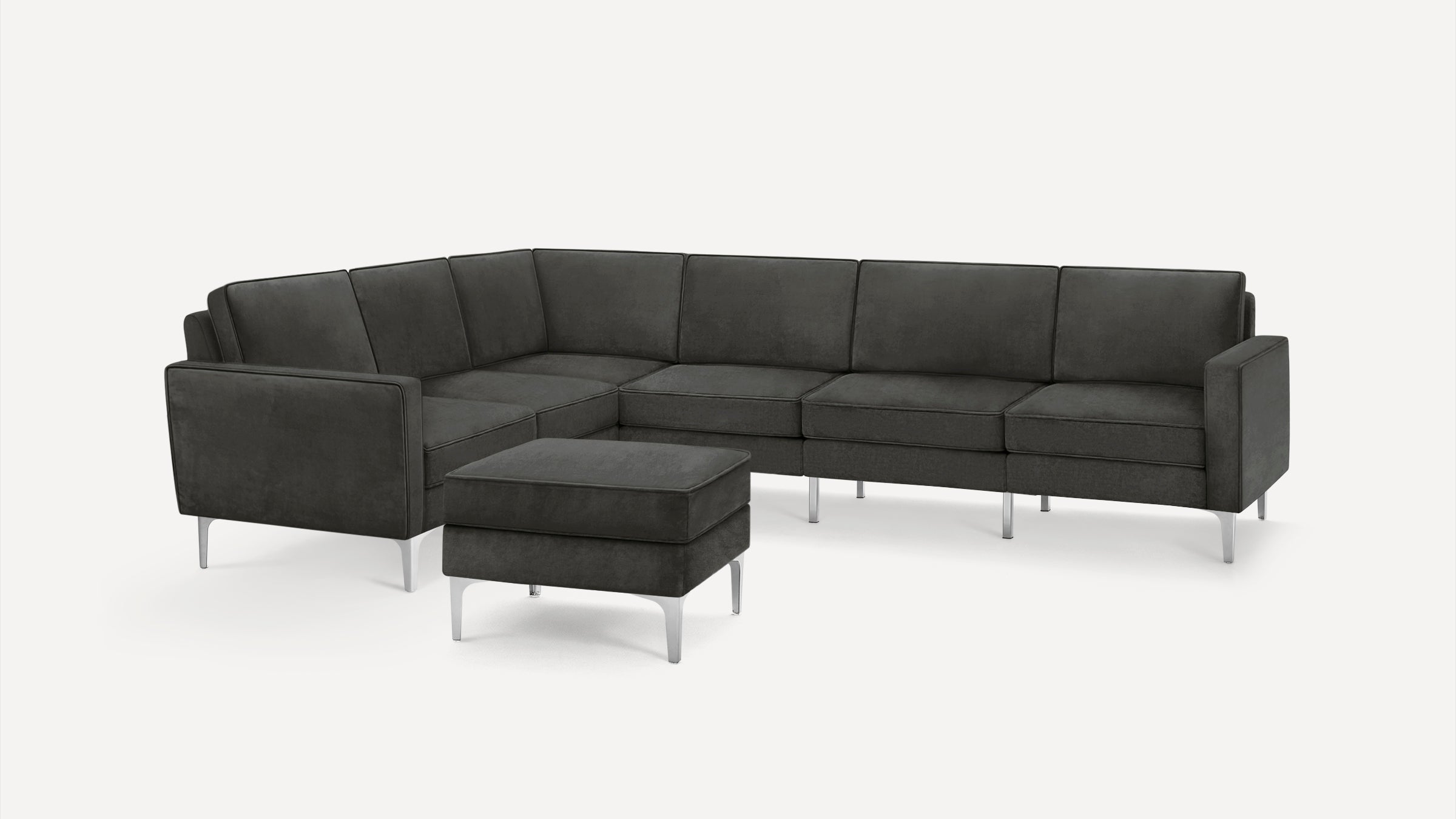 Dark gray L-shaped sectional sofa with matching ottoman, featuring clean lines and silver metal legs on a white background.