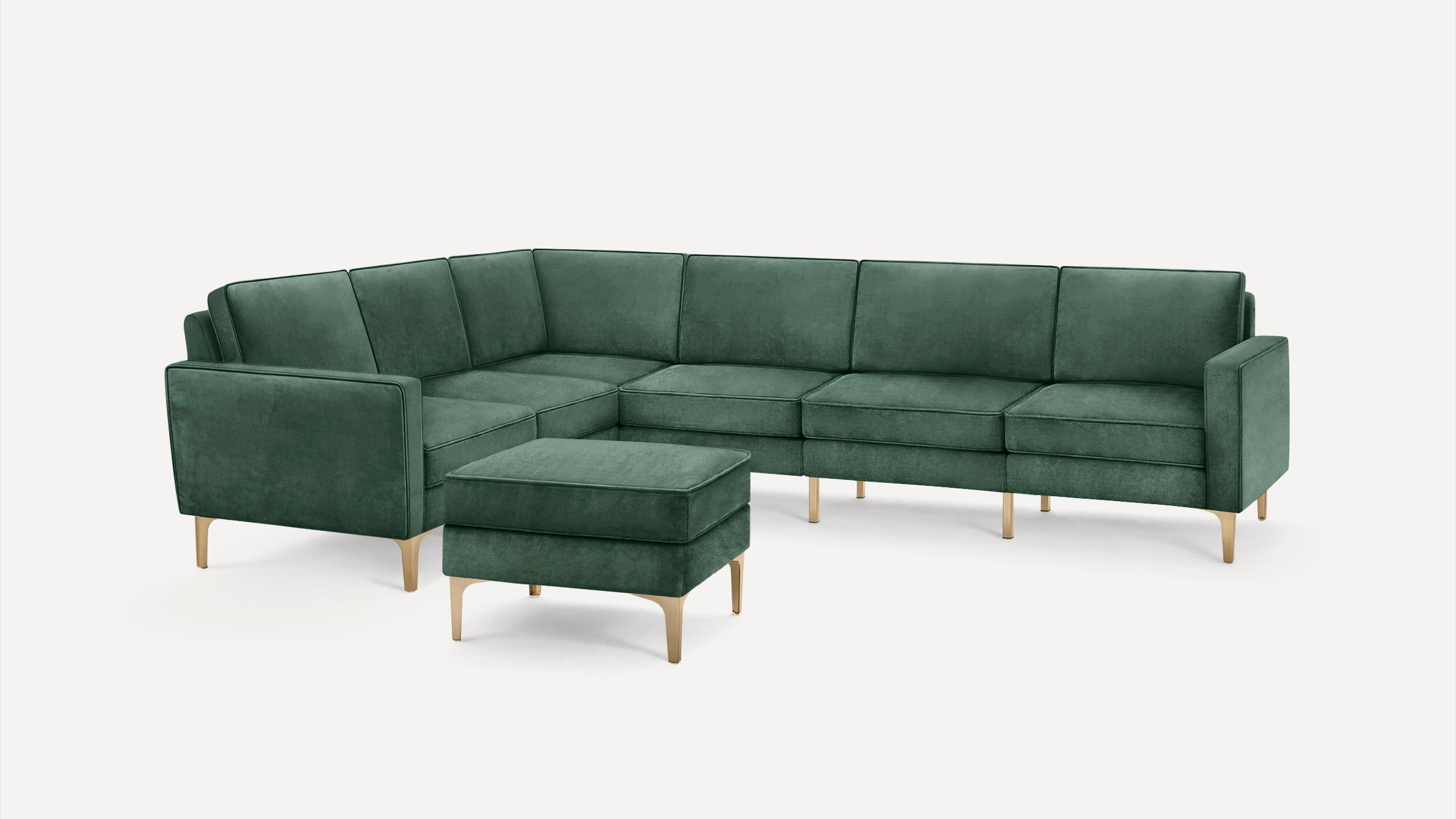 Green velvet L-shaped sectional sofa with matching ottoman, featuring sleek gold metal legs and clean modern design.