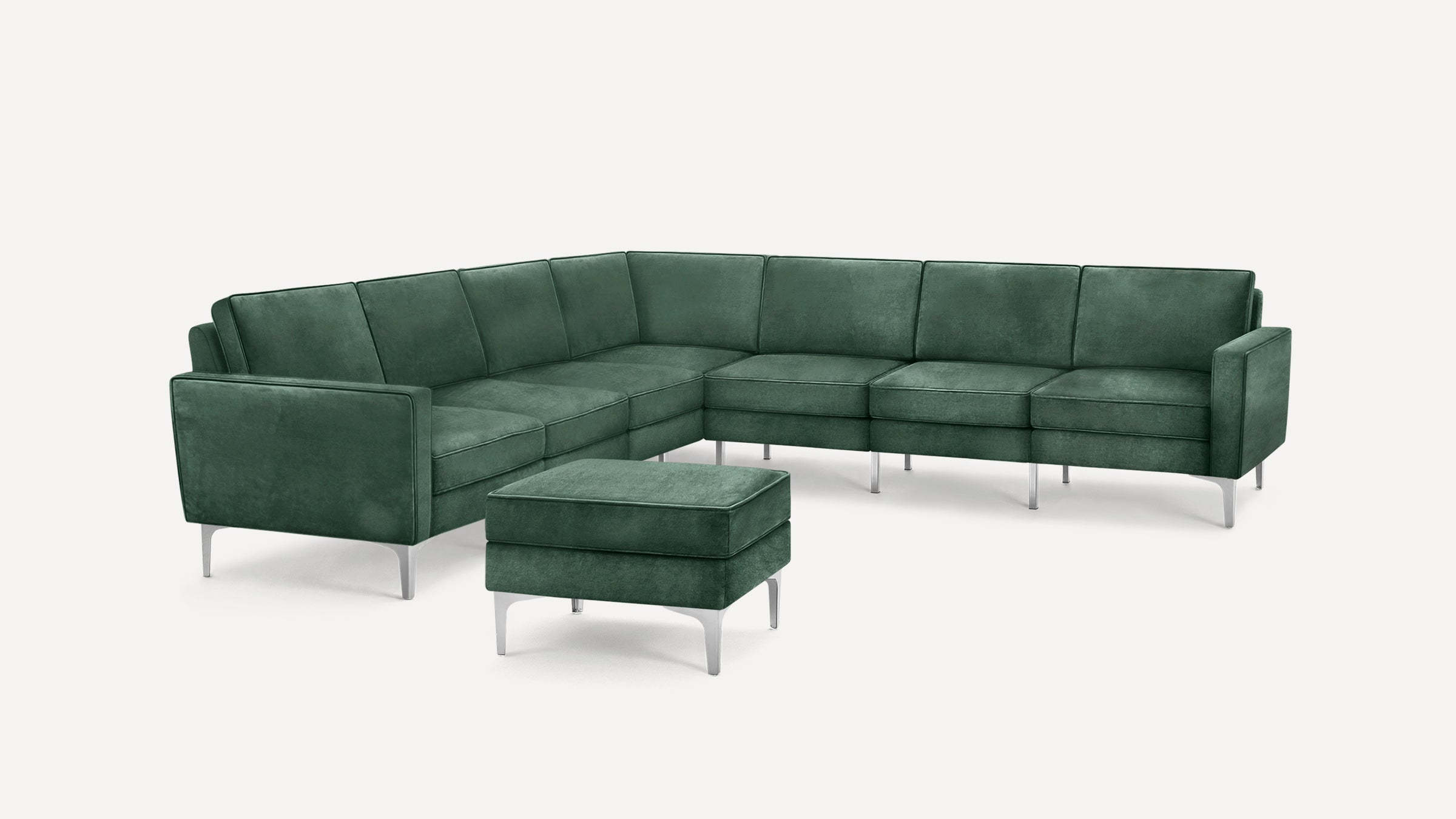 Modern dark green velvet sectional sofa with metal legs and matching ottoman, shown on white background.