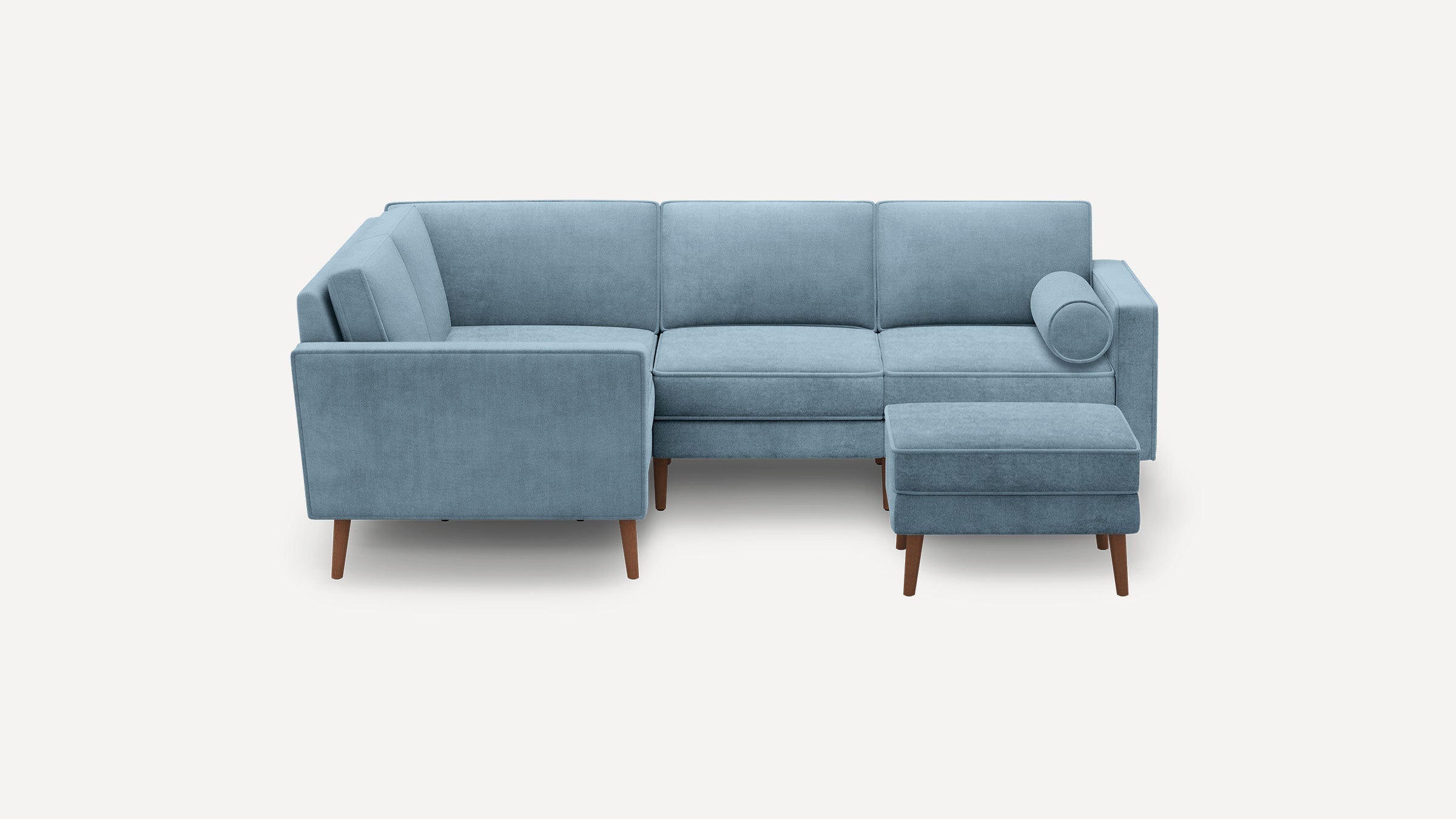 Light blue L-shaped sectional sofa with wooden legs, matching ottoman, and a cylindrical bolster pillow.