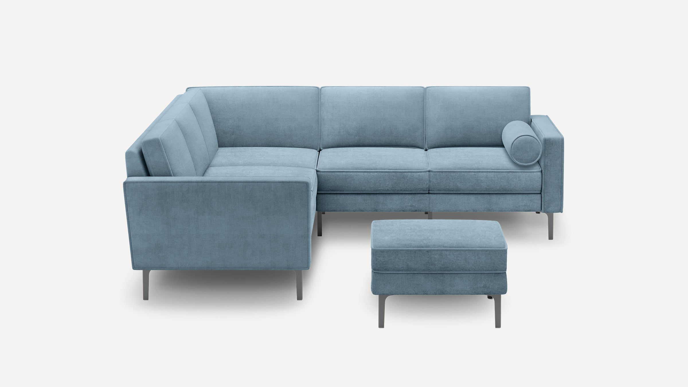 Modern light blue sectional sofa with clean lines, metal legs, and a matching ottoman, featuring a cylindrical bolster pillow.