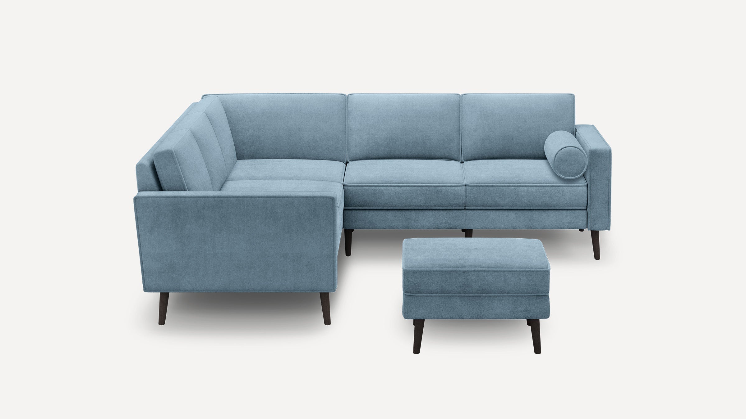 Modern light blue L-shaped sectional sofa with matching ottoman, tufted cushions, and dark tapered wooden legs.